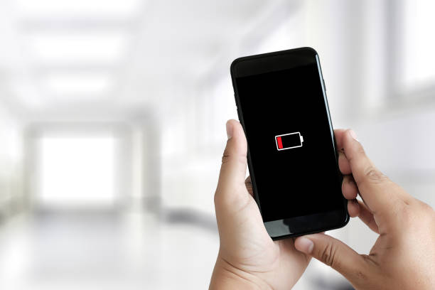 istock Close up man hands using smart phone battery low charged battery screen 948833832