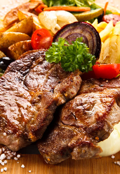 istock Grilled beefsteak, baked potatoes and vegetables on cutting board 948856702