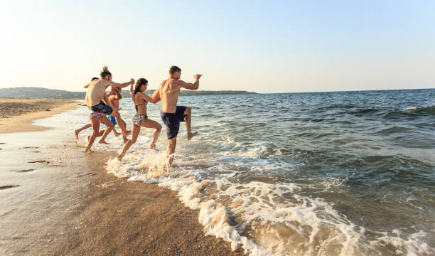 istock Friends jumping in the sea 948857216