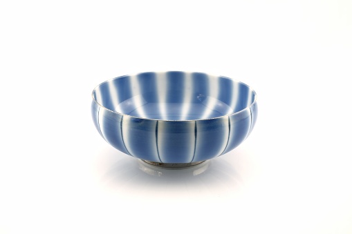 Blue and white striped bowl isolated on white background.