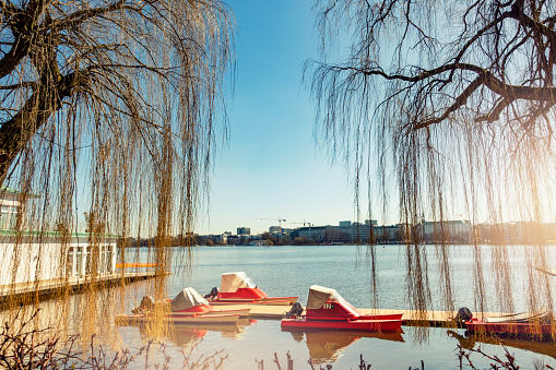 Small red boats on the jetty at the Aussenalster in spring on a sunny day