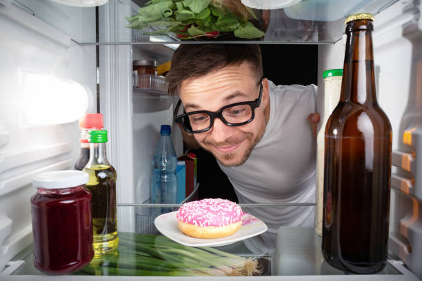 istock Nerd happy about a donut in the fridge 948863356