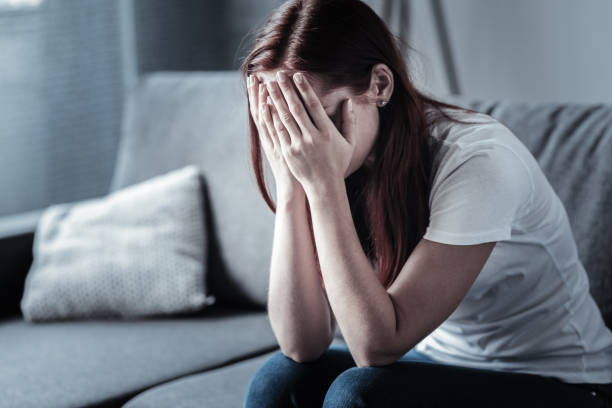 istock Young depressed woman hiding her face 948864396