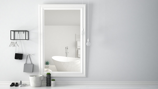 Scandinavian entrance lobby hall with mirror reflecting bright bathroom with bathtub, minimalist white interior design