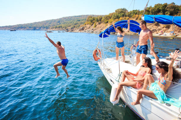 istock Young people jumping from yacht 948864542