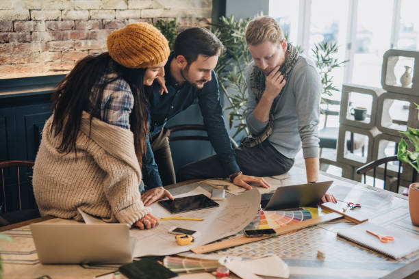istock Team of freelance architects using laptop at casual office. 948864584