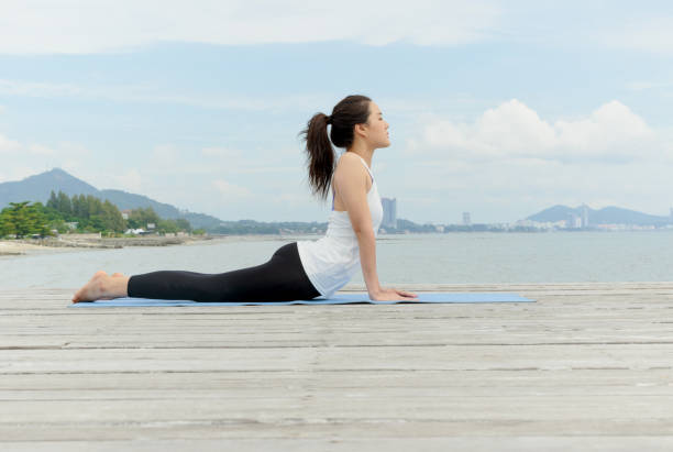 istock Young Asian woman practicing yoga at seashore 948867948