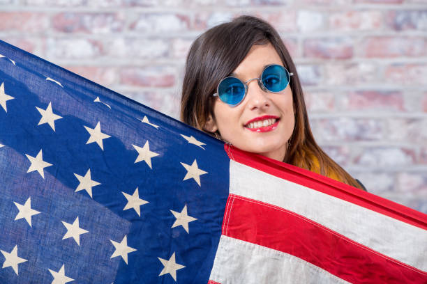 istock a young brunette with blue sunglasses and american flag 948868422