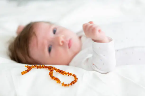 Photo of 3 month old  beautiful, cute baby with amber necklace
