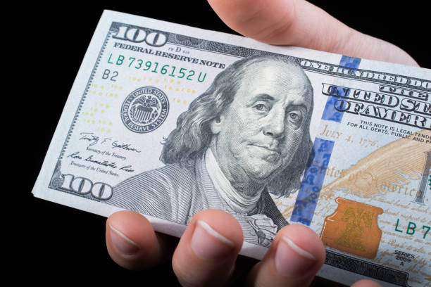 istock Hand holding American dollar  isolated on black background 948875856
