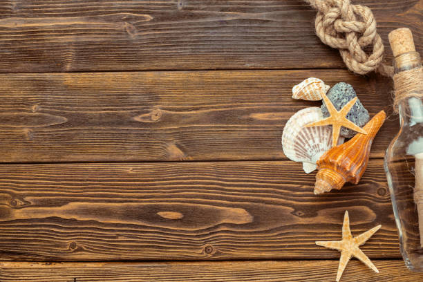 istock Seashells border on wood. Marine background 948879556