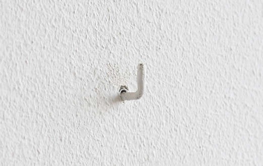 Painted small hook hanging in a wall