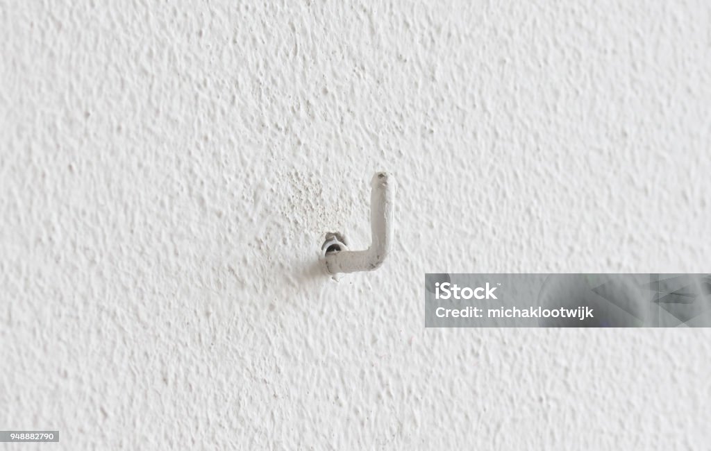 Painted small hook in a wall Painted small hook hanging in a wall Hook - Equipment Stock Photo