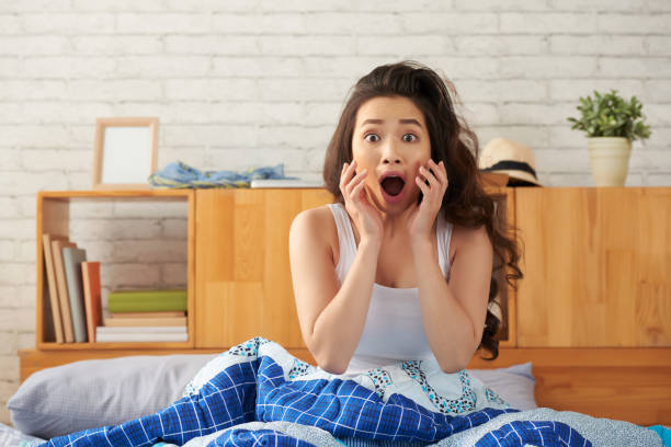 Oversleeping Portrait of shocked Asian woman overslept horror waking up bed women stock pictures, royalty-free photos & images