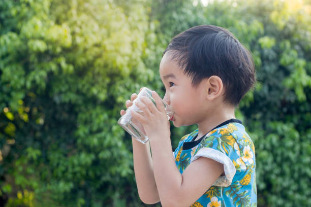 istock Asian Cute Boy drinking water for Healthy and Refreshing with green tree background. 948887334