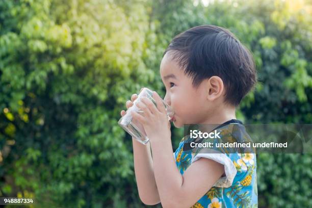Asian Cute Boy Drinking Water For Healthy And Refreshing With Green Tree Background Stock Photo - Download Image Now
