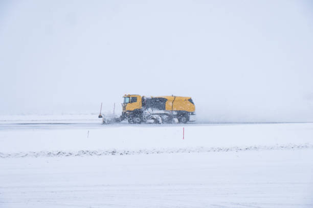 istock Yellow snow ploughs plowing snow cover road in blizzard 948890654