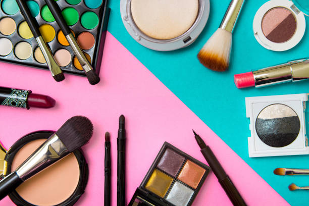 istock Brushes with an eyeshadow palette and lipstick in pink and mint geometric background. Decorative cosmetics for professional makeup. Eyeshadow colors trend. 948890804