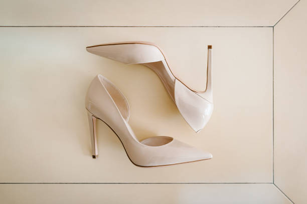 istock Stylish lacquered elegant classic beige shoes are isolated, lying on a light pastel table. Wedding accessory standing. Close up. flat lay. top view. 948895646