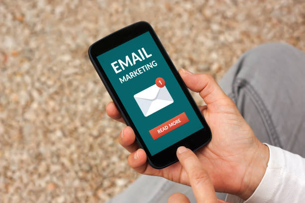 istock Hands holding smart phone with email marketing concept on screen 948898328