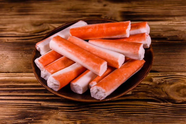 istock Ceramic plate with crab sticks on wooden table 948900594
