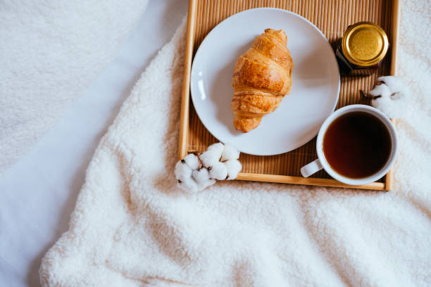 istock Coffee and croissant in bed 948905506
