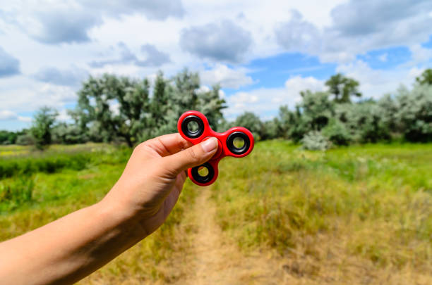 istock Red fidget spinner in female hand 948905900