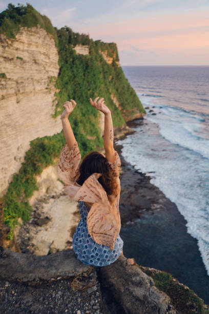 istock Woman on cliff with view on  ocean in Bali 948911572