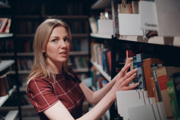 istock Young beautiful blond student girl with book 948915200