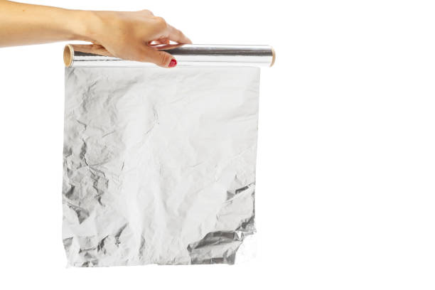 istock human hand holding a roll of foil on a white background 948921334