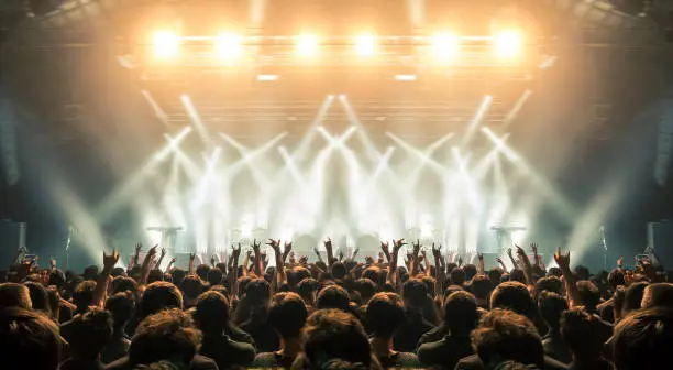 Concert wide arena with happy fans clapping.