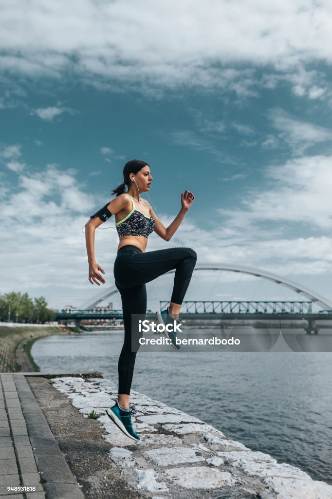 Making great progress Young sportswoman exercising outdoors Knee Stock Photo