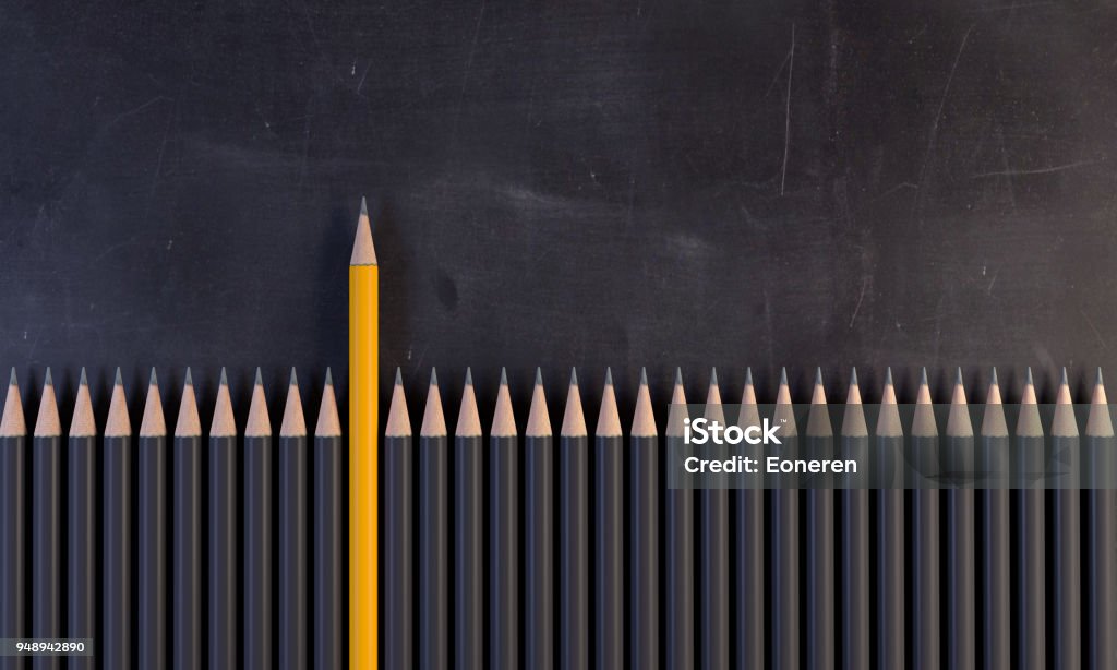 Orange Colored Pencil Standing Out From The Crowd An orange colored pencil between the gray ones, on the blackboard. ( 3d render ) Standing Out From The Crowd Stock Photo
