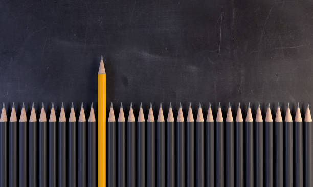 Orange Colored Pencil Standing Out From The Crowd An orange colored pencil between the gray ones, on the blackboard. ( 3d render ) standing out from the crowd stock pictures, royalty-free photos & images