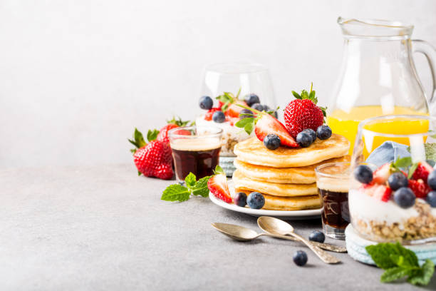 Healthy summer breakfast Breakfast background with fresh pancakes and berries on light gray concrete table. Healthy food concept with copy space. brunch stock pictures, royalty-free photos & images