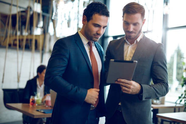 istock Two young businessmen discussing business strategy using digital tablet 948966090