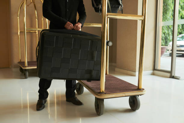 Taking care of luggage Hotel servant putting luggage on cart bellhop stock pictures, royalty-free photos & images