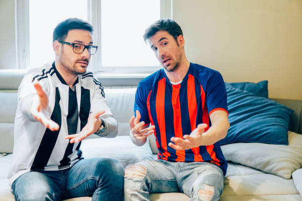 istock Two football supporters talking and pointing at TV 948988132