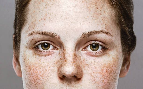 Eyes woman Young beautiful freckles woman face portrait with healthy skin Eyes woman Young beautiful freckles woman face portrait with healthy skin. Studio shot. Isolated on gray. close up stock pictures, royalty-free photos & images