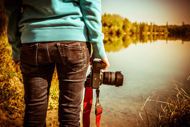 istock woman with camera taking pictures on a lake 949017866