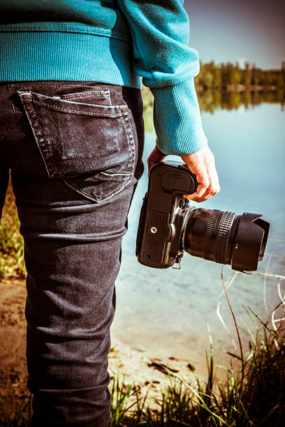 istock woman with camera taking pictures on a lake 949017940