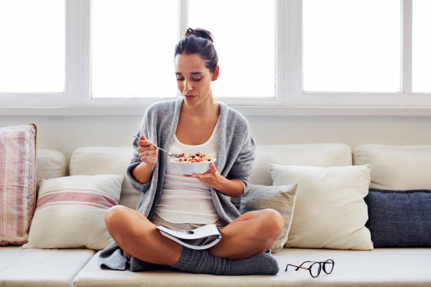 assicurarsi che abbia le migliori possibilità in una giornata produttiva - eating women breakfast cereal foto e immagini stock