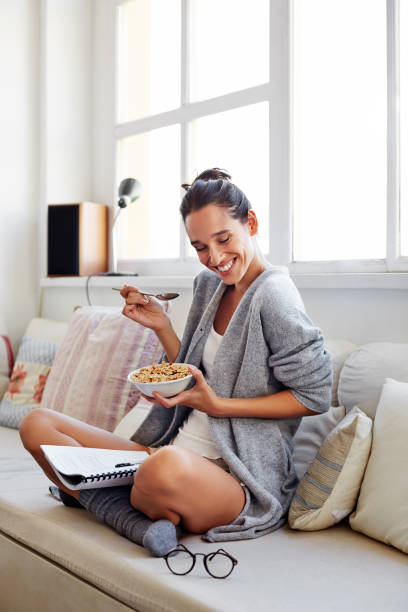 the secret to a successful day? a healthy breakfast - eating women breakfast cereal imagens e fotografias de stock