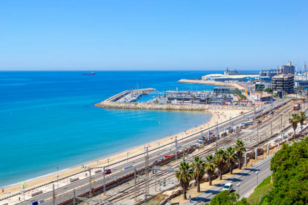 Landscape of coastline of Catalonia, view of with Mediterranean Balcony, Tarragona, Spain. Panoramic view of coast of Tarragona, beach in La Pineda in sunny day with railway tracks along coastline and port with ships and yachts, Tarragona, Catalunya, Spain cambrils stock pictures, royalty-free photos & images