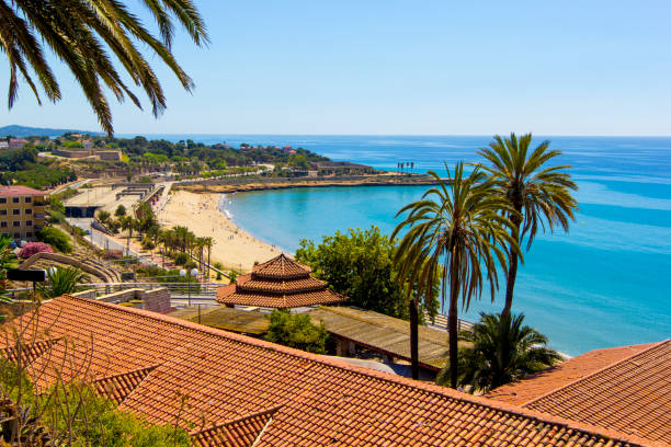 Panoramic view of coast of Tarragona in sunny day, Catalunya, Spain. View of coastline of Costa Dorada in Miami Platja, sea, beach, palms and tiled roofs of houses with Mediterranean Balcony, Tarragona, Catalunya, Spain cambrils stock pictures, royalty-free photos & images