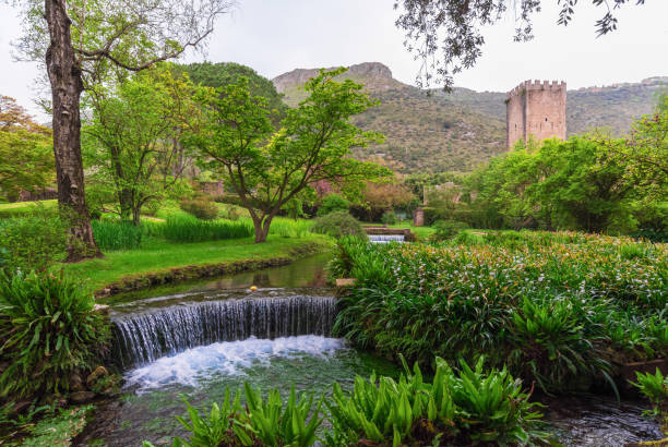 Ninfa Garden and Medieval Town (Lazio, Italy) Garden of Ninfa, Italy - 15 April 2018 - A natural monument with medieval ruins in stone, flowers park and an awesome torrent with little fall. Province of Latina, Lazio region, central Italy. sermoneta stock pictures, royalty-free photos & images