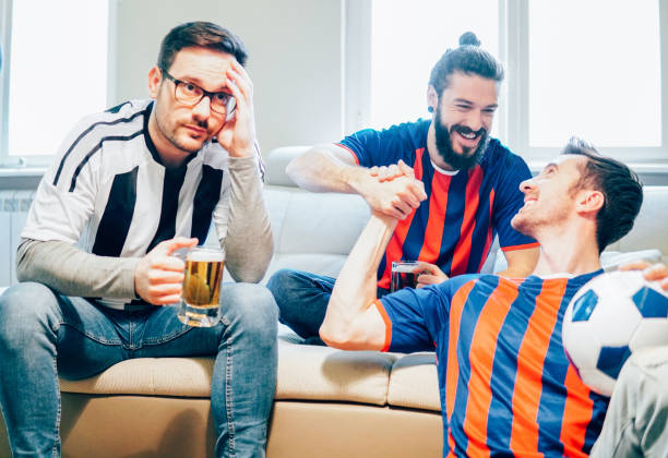 istock Male football supporters cheering for different teams 949031946