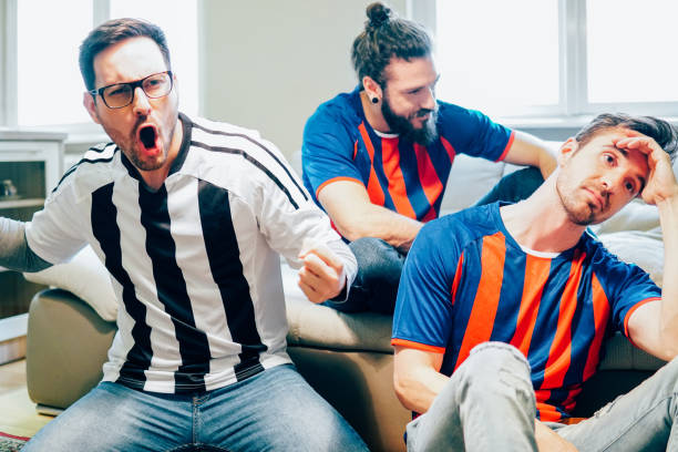 istock Different team supporters watching soccer game on TV 949032034