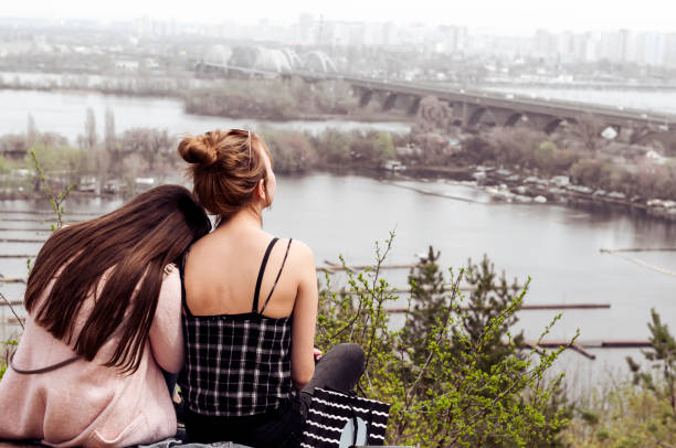 istock two girls relaxing sitting on a high mountain slope 949033322