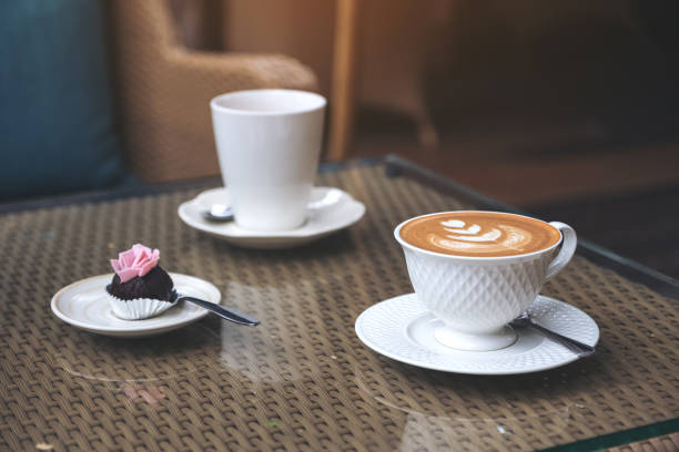 istock A piece of snack and two white coffee cups on table in cafe 949036128